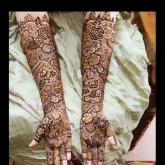 This full-coverage bridal mehndi for Tabassum features a mix of bold roses and delicate leafy vines. The contrast between the filled and empty spaces makes the floral patterns pop.