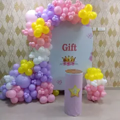 A princess-themed setup for a 4th birthday. This decoration features a custom arch backdrop and a colorful balloon arrangement in pastel pink, purple, and yellow.