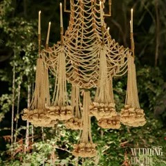 A full view of our custom-made pearl and floral chandelier. This masterpiece, with its cascading strands of pearls, delicate flowers, and candle-like lights, is a true testament to our dedication to artistry and opulence.