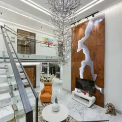 Another angle of the double-height space, showing a custom wood and resin art wall that conceals the television. This is how I blend art, technology, and architecture into a single, cohesive feature.