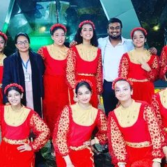 With a group of student performers in their beautiful red costumes for the Ryan Festival. I work with schools to create visually stunning thematic performances.