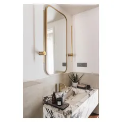 In this powder room, a monolithic marble vanity creates a bold statement. The dramatic veining of the stone is complemented by a simple, elegant brass mirror and fixtures.