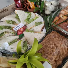 A classic breakfast hamper featuring freshly made vegetarian sandwiches, a sweet baked cake, and other morning snacks, all packed and ready to enjoy.