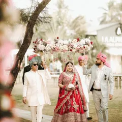The bride's grand entrance, walking towards her future under a delicate 'phoolon ki chadar'. I capture this iconic bridal walk, focusing on her serene expression and the support of her loved ones at this Goa destination wedding.