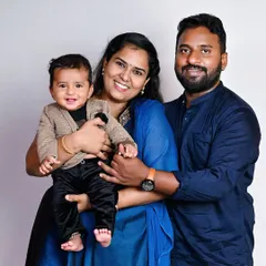 A simple, happy family portrait against a clean studio background. Sometimes the most beautiful photos are the ones that capture the pure joy of being together, like this family holding their smiling baby.