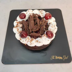 A classic Black Forest cake, topped with fresh cherries and generous chocolate shavings. A timeless dessert for any occasion.