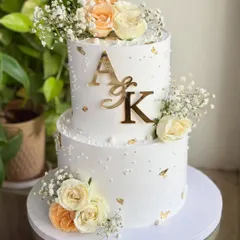 When love is golden. ✨ I designed this timeless two-tier engagement cake with delicate fresh florals, soft pearls, and hints of gold leaf. It’s perfect for whispering “she said yes” in the most graceful way.