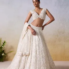 This ivory and gold lehenga by Mirroir is the essence of modern bridal elegance. The silhouette is classic, but the intricate hand-embroidery and shimmering detail give it a contemporary feel, perfect for the bride who wants a timeless look with a touch of the now.
