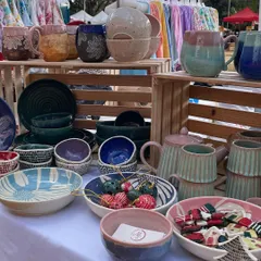 A wide shot of my stall at a bustling outdoor market. I love creating a diverse display with a mix of mugs, bowls, teapots, and festive decor to show the full range of my work.