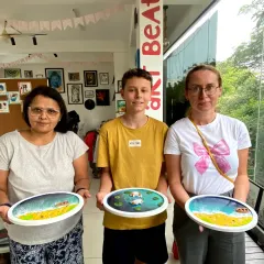 A group of happy participants proudly shows off the galaxy resin clocks they created in our workshop. It's a fun experience for friends, families, or individuals looking for a creative weekend activity.