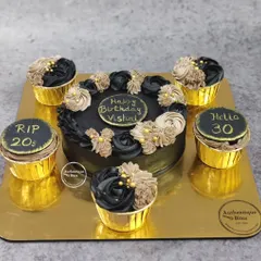 This glamorous black and gold cake and cupcake set was designed for a 30th birthday celebration. The combination allows for a central cutting cake while offering individual portions for guests, all unified by a sophisticated colour theme.