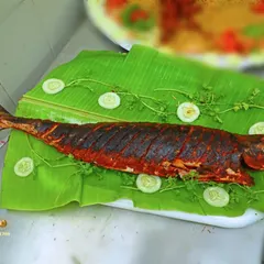 A whole fried fish, beautifully presented on a banana leaf. This is a popular choice for seafood lovers and adds a special touch to any menu.
