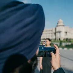 A creative shot capturing a photo within a photo, with Bangalore's Vidhana Soudha in the background. This meta-photograph is a playful way to document the pre-wedding shoot itself.