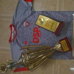 Another angle on our achievements. This shot features a large winner's trophy and a "Best Coach" plaque, representing the combination of player talent and expert guidance that leads to victory.