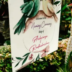 A close-up of the beautifully designed welcome sign for the naming ceremony, featuring watercolor lovebirds.