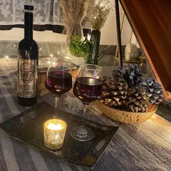 A cozy setup with wine, candles, and rustic decor like pinecones, perfect for a winter evening.