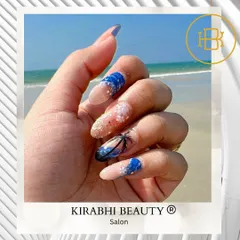 Your nails can be a whole vacation vibe. This beach-themed nail art includes glittery sand, blue ocean waves, and a hand-painted palm tree silhouette.