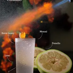 The Pomello cocktail, a fiery mix of burnt honey, mezcal, lime, and grapefruit soda. The blowtorch caramelizes the honey, adding a smoky depth to this refreshing drink.