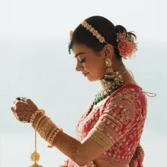A beautiful profile shot of the bride, delicately holding her kaleeras against the backdrop of the sea. The soft light and her serene expression make this a timeless and elegant bridal portrait.