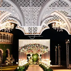 The entrance to the 'Blue Palace' reception, where intricate white arches frame a floral-draped walkway, giving guests a royal welcome.