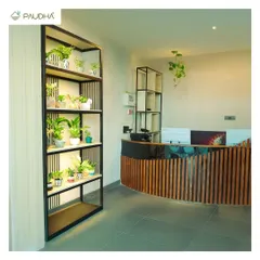 The reception desk of a commercial space, where first impressions matter. I designed this custom desk with a curved wooden slat front and added a tall, backlit shelving unit filled with plants to create a striking, modern look.