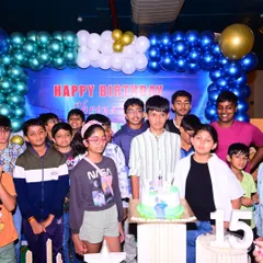 I also cover birthday parties for teenagers. This is a group photo from a 15th birthday celebration, capturing the birthday boy with his friends in front of a custom blue and gold balloon backdrop I set up for the event.