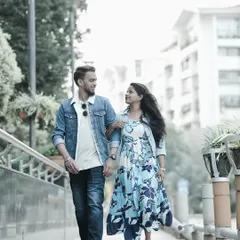 A candid shot of a couple walking and talking on a city bridge, capturing a natural and modern urban pre-wedding moment.