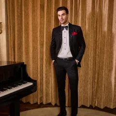 Black and white remains a timeless classic. I designed this tuxedo with a unique textured lapel and paired it with a crisp pleated shirt and a silk bow tie. The pop of red from the pocket square adds a touch of personality, making it perfect for a formal gala or reception.