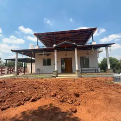 The front elevation of the villa, showing the wide porch supported by classic white pillars. This design creates an impressive and welcoming entrance while providing ample shaded outdoor living space.