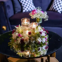 A beautiful floral and candle arrangement on a coffee table in a lounge area. These smaller touches ensure that the theme and sense of luxury are carried into every corner of the event space.