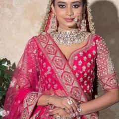 A beautiful bride in a classic hot pink lehenga. The silver embroidery and sweetheart neckline offer a modern touch to a traditional color, perfect for the main ceremony.