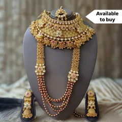 Introducing a masterpiece from my exclusive 'for sale' collection. This regal bridal set includes a broad choker, a layered rani haar with intricate floral motifs, and matching jhumkas, all crafted with polki and ruby-colored stones. This is an heirloom piece, designed to be treasured for generations.