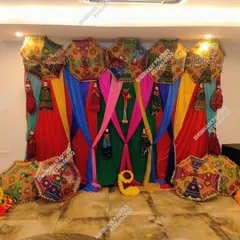 A colorful and vibrant backdrop with Rajasthani umbrellas and puppets, ideal for a Mehendi or Sangeet ceremony.