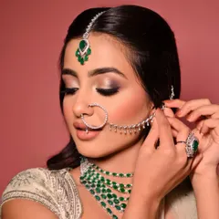 A beautiful shot showcasing the soft, blended eyeshadow and the delicate details of the jewellery. The hair is styled in a classic half-updo to keep the focus on the face and accessories.