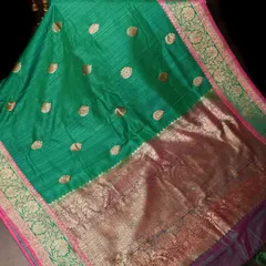 A gorgeous green silk saree with a rich gold pallu. The body features delicate gold butis, making it a beautiful choice for festive occasions.