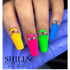 A full set of coffin-shaped nails in vibrant matte neon colors, each accented with a cuff of sparkling rhinestones.