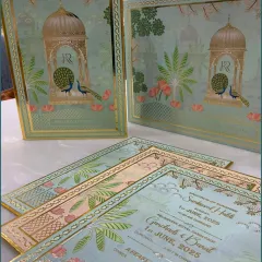 A closer view of the wedding invitation cards, showcasing the intricate gold foil work and the personalized details for the wedding events.
