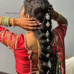 A beautiful, thick braid adorned with crystal flower accessories. This is a modern and glamorous take on a traditional wedding hairstyle.