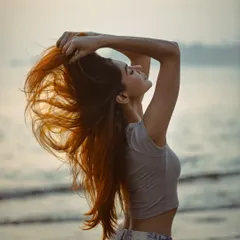 Captured at the beach, this image showcases how natural wind can be used for stunning hair photography. The sunset backlighting makes every strand glow, highlighting the hair's color and texture as it flows in the sea breeze.