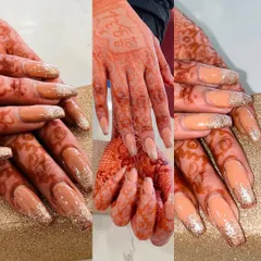 These bridal nail extensions were designed to complement the client's beautiful henna. The long, square-shaped nails feature a nude base with a sparkling gold glitter fade from the tips, creating a glamorous and festive look.