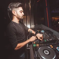 A side profile of me at the decks, making precise adjustments on the mixer. Every track is carefully selected and mixed to maintain a seamless flow of energy.