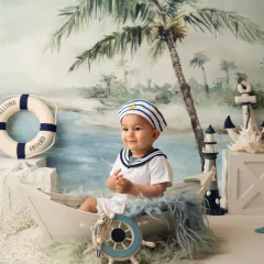 Ahoy, little sailor! This nautical-themed sitter session is perfect for adventurous little ones, complete with a boat, lifebuoy, and sailor suit.
