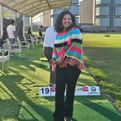 A member of our women's golf community smiles for the camera during her practice session. We provide a friendly and encouraging environment for everyone.