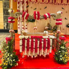 For a naming ceremony, the cradle is the star. Here, we've decorated a beautiful silver cradle with garlands of red and white flowers, accented with delicate lotus buds, making it a perfect centerpiece for welcoming the new baby.