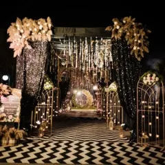 I love creating dramatic entrances for Sangeet nights. This design uses shimmering black drapes, cascading fairy lights, and pampas grass arrangements to build a glamorous and inviting walkway for your guests.