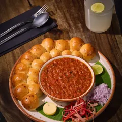 This is Pav Bhaji, reimagined the Comorin way. We serve a rich, deeply spiced bhaji, slow-simmered to perfection, alongside oven-fresh, buttery paos and all the essential fixings. It’s a respectful nod to a classic, elevated with our signature touch.
