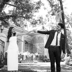 A fun and quirky black and white shot of the couple reaching for each other. This playful pose shows their unique personalities and the fun they have together.