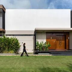 The architectural facade of the Celadon residence combines clean, monolithic forms with warm wood and lush tropical plantings. This composition demonstrates our approach to modern architecture that is both striking and harmoniously integrated with its natural surroundings.