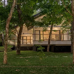 Exterior views of The Leaf Poomala, where the building's stilted metal structure allows it to sit lightly on the terrain, preserving the natural landscape.