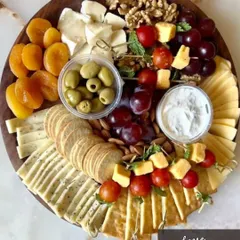 Our classic Cheese Platter is a crowd-pleaser, featuring a curated selection of cheeses, crackers, fresh grapes, olives, walnuts, and dried apricots. It's an elegant addition to any party or a perfect gourmet gift.